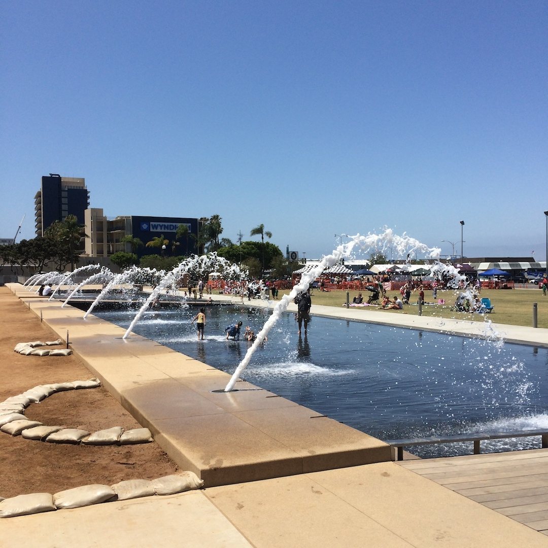 interactive fountains and lawn at Waterfront Park with the harbor in the background