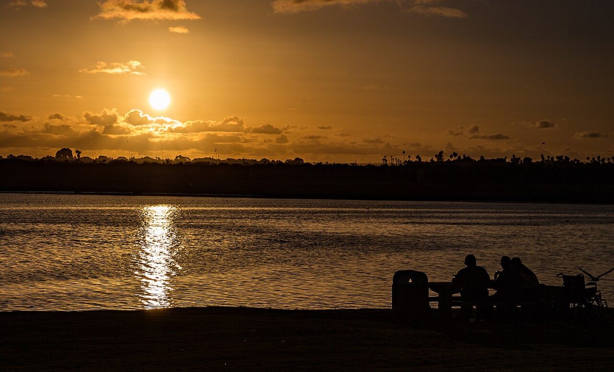 Calm water and paddleboarders at sunset in Mission Bay Park San Diego