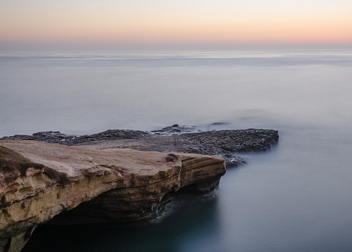 Sunset Cliffs in Ocean Beach, San Diego, with waves crashing below sandstone bluffs at golden hour