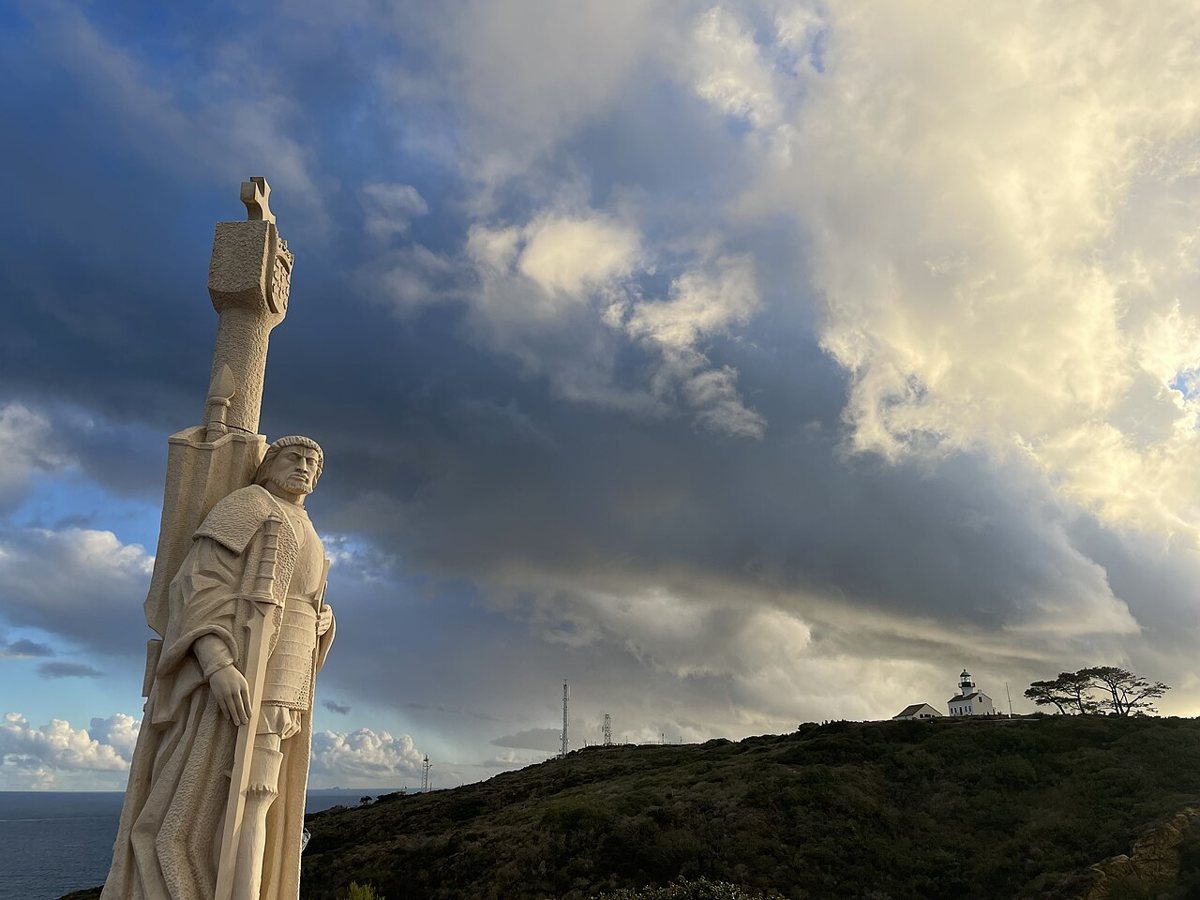 The Cabrillo statue with the Old Point Loma Lighthouse on the ridge behind it
